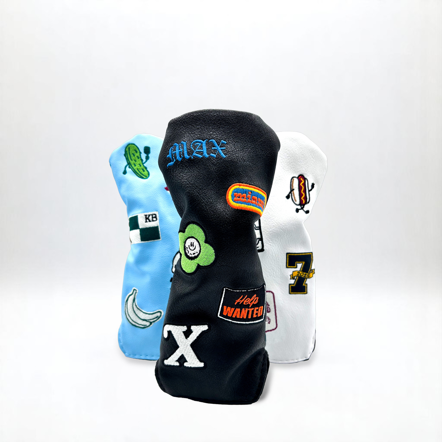 Hybrid golf club head covers with custom patches on white backdrop