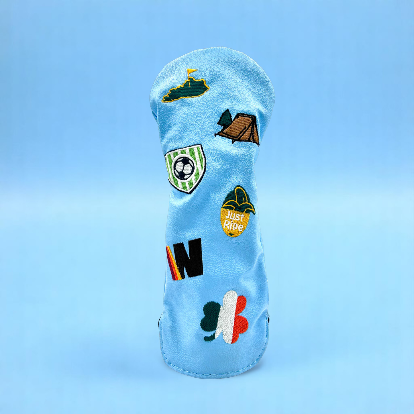 Blue golf club wood head cover with custom patches on blue backdrop
