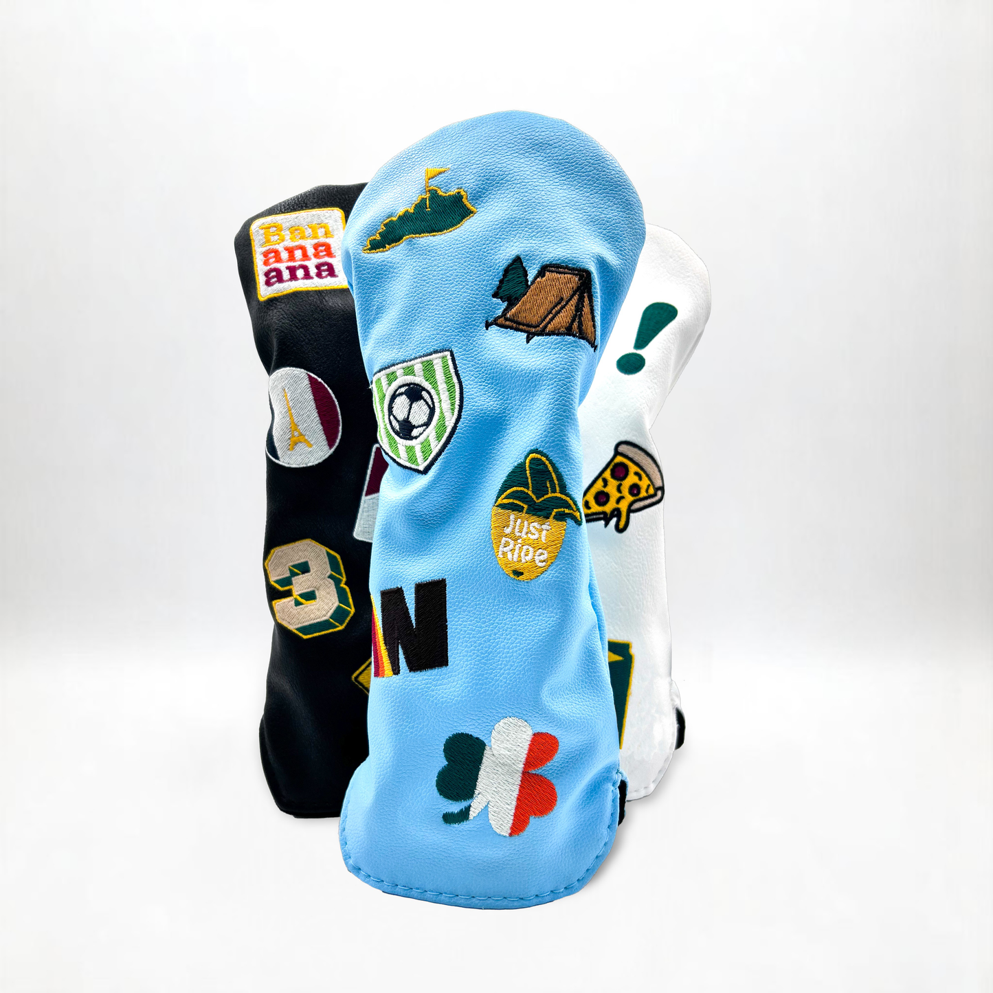 Wood golf club head covers with custom patches on white backdrop