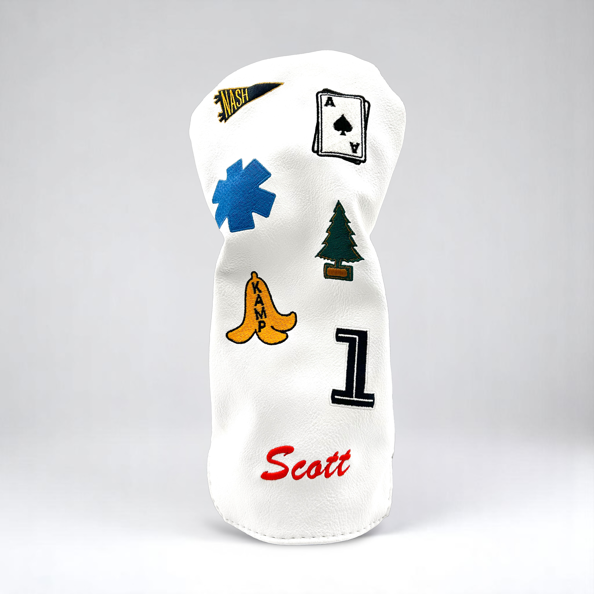 White golf club driver head cover with custom patches on white backdrop
