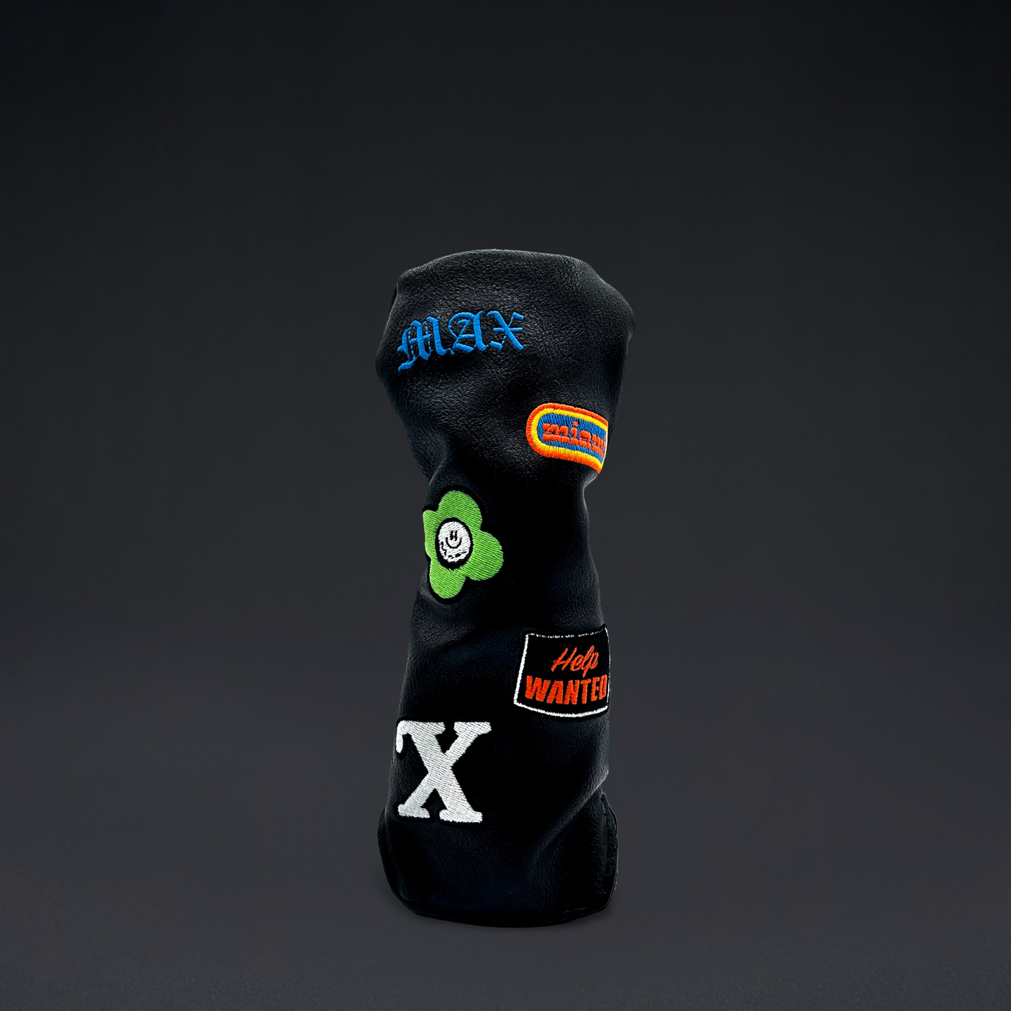 Black golf club hybrid head cover with custom patches on black backdrop